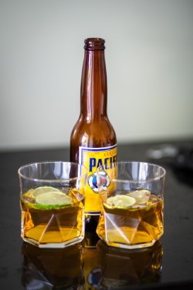 A bottle of beer, two full glasses.